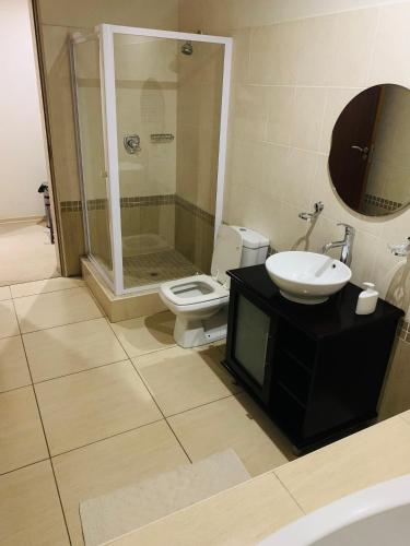 ein Bad mit einem WC, einem Waschbecken und einer Dusche in der Unterkunft Atonement private room in Matsapha