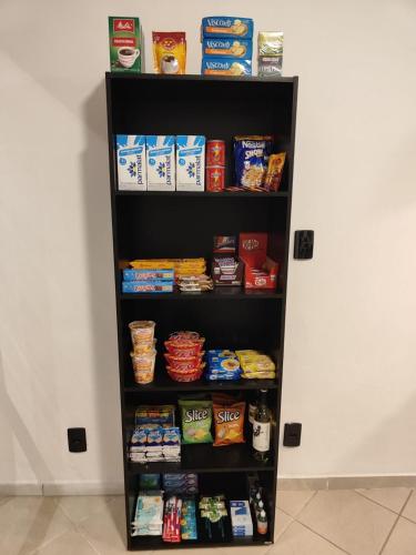 a black book shelf filled with food at VILLA BILAC - Studios próximo à Vila Germânica Bairro da Velha in Blumenau