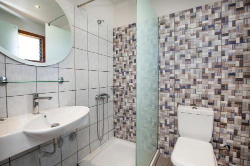 bagno con servizi igienici, lavandino e specchio di Hotel Thetis a Limenas
