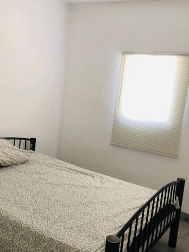 1 dormitorio con cama y ventana con edredón en Bonito y cómodo departamento 2R, en Mexicali
