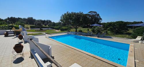 a swimming pool with blue water in a yard at Quinta do Lagar - 10 in Albufeira