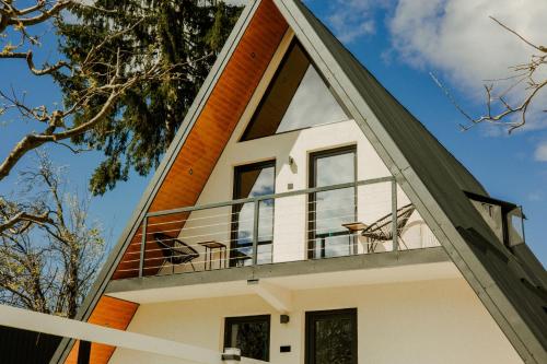 a house with a large window on the side of it at Cabana Serenity - A-frame in Pucheni