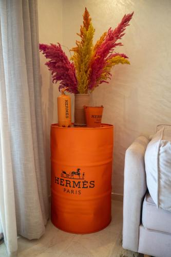 an orange barrel with plants on top of it at Magnifique appartement moderne de 2 chambres avec piscine à 10 min du centre de Marrakech in Marrakech