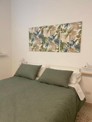 ein Schlafzimmer mit einem Bett mit zwei grünen Kissen in der Unterkunft Alloggio dei Volsci in Nettuno