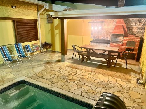 a patio with a picnic table and a swimming pool at Casa Piscina Centro Serra Negra 500m Fontana Trevi in Serra Negra