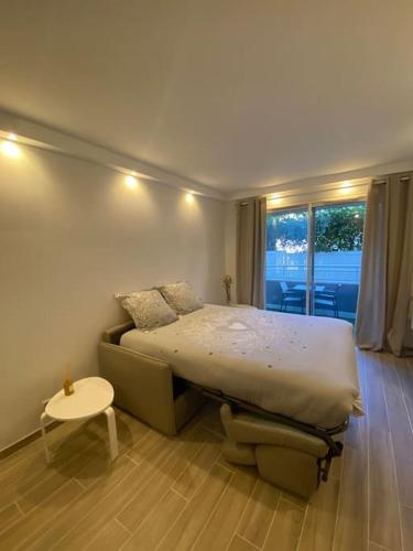 une chambre avec un lit, une table et une fenêtre dans l'établissement Appartement neuf Pointe Croisette, 50 m de la mer, à Cannes