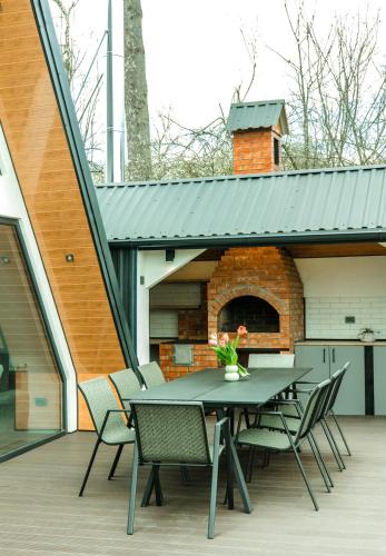 a patio with a table and chairs and a brick oven at Cabana Serenity - A-frame in Pucheni