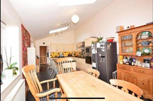 uma cozinha com uma mesa de madeira e um frigorífico em Anita's Home in Kidderminster em Kidderminster