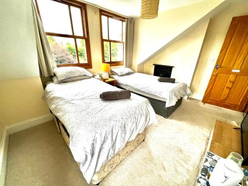 um quarto com 2 camas e uma janela em Anita's Home in Kidderminster em Kidderminster