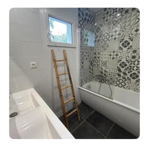- une salle de bains avec une échelle à côté d'une baignoire dans l'établissement Jolie villa familiale bohème et moderne, à Aspères
