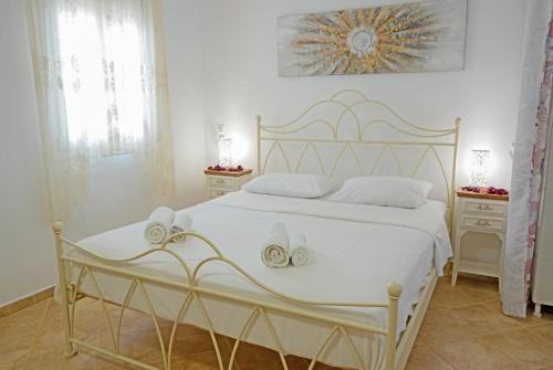 a bedroom with a white bed with white sheets and towels at Avlemonas Guest House in Avlemonas