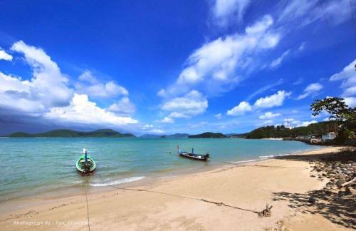 two boats in the water on a beach at Seaview At Cape Panwa in Panwa Beach