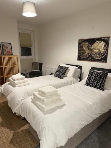 2 posti letto in camera con asciugamani di RomaVita Apartment near Heathrow a Hayes