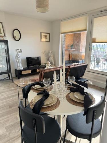 una sala da pranzo con tavolo, sedie e TV di RomaVita Apartment near Heathrow a Hayes