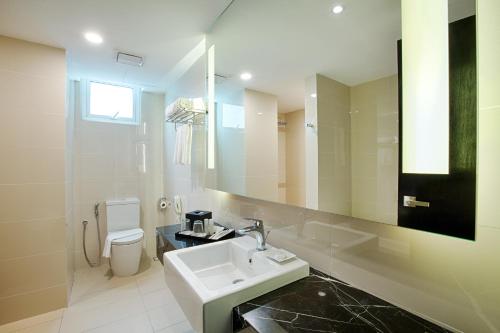 a bathroom with a sink and a mirror and a toilet at WP Hotel in Kuala Lumpur