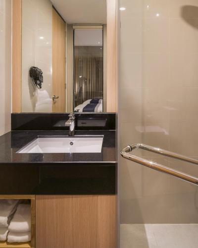a bathroom with a sink and a mirror at Zayn Hotel Bangkok - Airport Link Access in Bangkok
