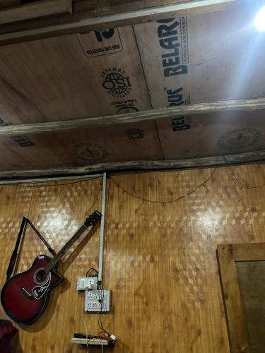 a guitar on the wall of a room at Wild trip cafe in Kasol