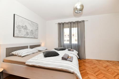 una camera da letto con un grande letto con due cuscini di Apartman Punta Sole a Zara (Zadar)