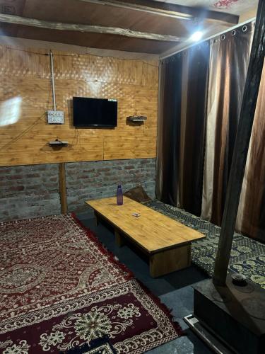 a room with a table and a tv on a wall at Wild trip cafe in Kasol
