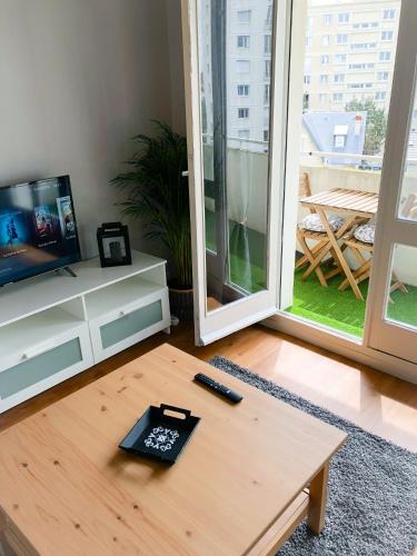 - un salon avec une table basse et une télévision dans l'établissement Appartement 35m² terrasse sud, à Caen