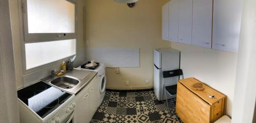 une petite cuisine avec un évier et un réfrigérateur dans l'établissement Appartement 35m² terrasse sud, à Caen