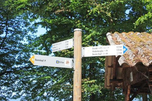 a pole with street signs in front of a building at Gästehaus Herda in Briedel