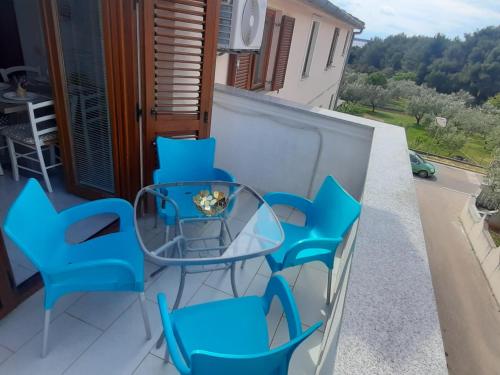 a glass table and chairs on a balcony at Apartment Mango in Fažana