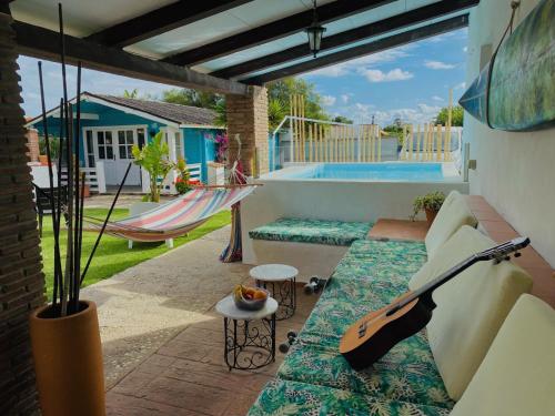 a guitar sitting on a couch on a patio with a swing at Kontiki Bungalows El Palmar in El Palmar