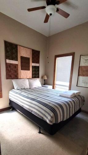 a bedroom with a bed with a ceiling fan at Flyers' Landing in Jacksboro