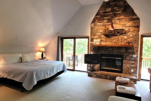 a bedroom with a bed and a stone fireplace at Flyers' Landing in Jacksboro