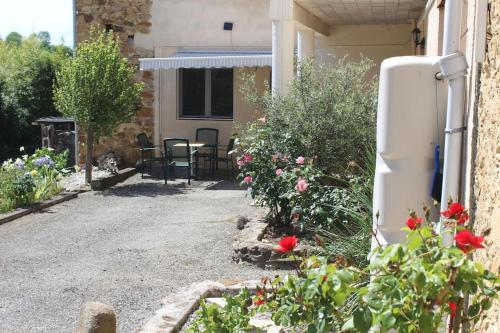 a refrigerator in the side of a house with flowers at Les Merens in Baulou