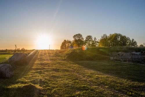 un campo con la puesta de sol a lo lejos en Hundiaugu, en Paslepa
