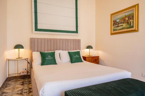 1 dormitorio con 1 cama blanca grande con almohadas verdes en Achilles Apartment en Giardini Naxos