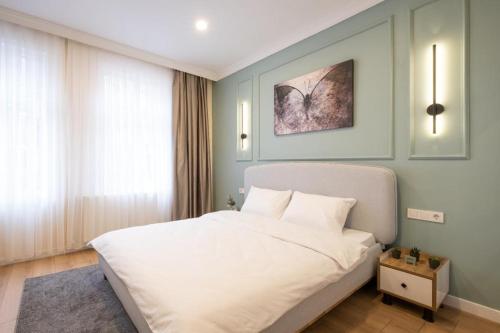 um quarto com uma grande cama branca num quarto em Green sophia suite em Istambul