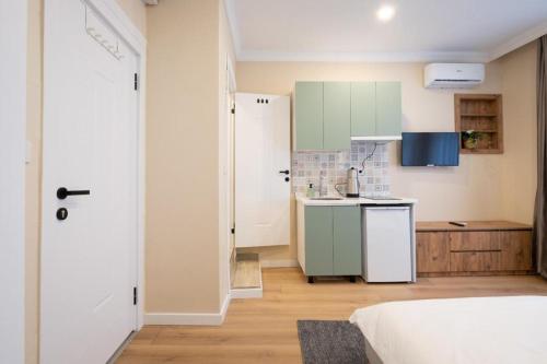 uma cozinha com armários verdes e um frigorífico branco em Green sophia suite em Istambul