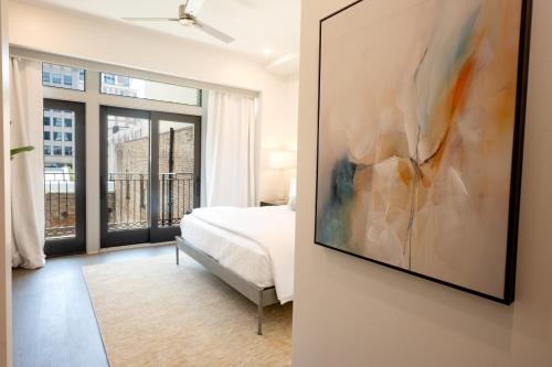 a bedroom with a bed and a painting on the wall at Harcol House in New Orleans