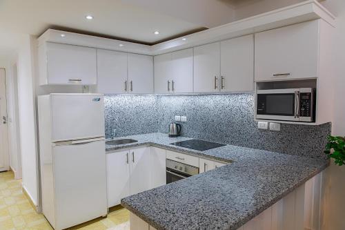a kitchen with white cabinets and a counter top at Beautiful Apartment in Egyptian Experience Resort in Sharm El Sheikh