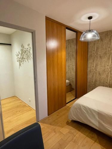 une chambre avec un lit et un grand miroir dans l'établissement Chambre proche de la citadelle, à Montmédy