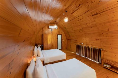 um quarto com 2 camas num quarto de madeira em Chay Lap Farmstay Phong Nha em Ðá Lòn