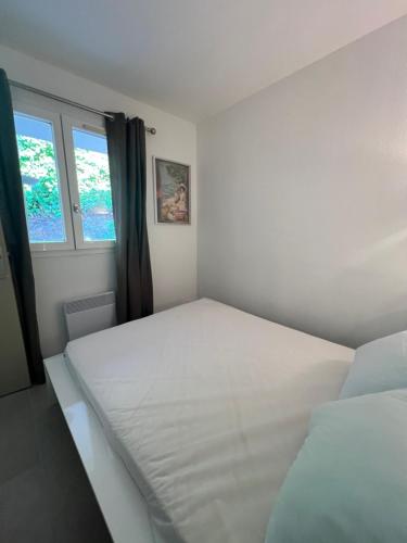 une chambre avec deux lits et une fenêtre dans l'établissement Appartement vue mer et piscine, à Saint-Raphaël