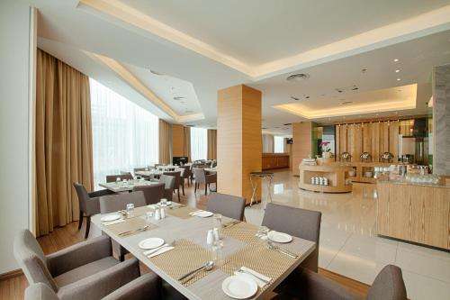 uma sala de jantar com mesas e cadeiras e um restaurante em WP Hotel em Kuala Lumpur