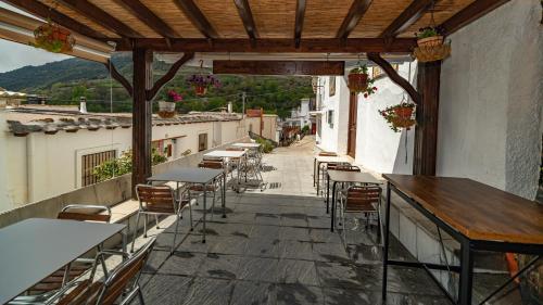 a patio with tables and chairs on a balcony at Hotel La Fragua II in Trevélez