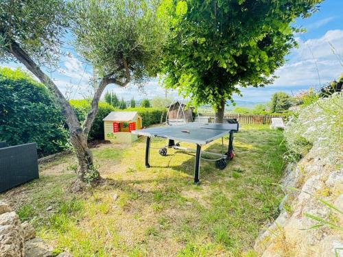 a ping pong table in a yard with a tree at Maison climatisée avec piscine proche bandol in Le Beausset