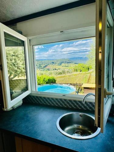 a kitchen with a sink and a window with a view at Maison climatisée avec piscine proche bandol in Le Beausset