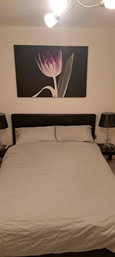 1 dormitorio con 1 cama con una flor rosa en la pared en Hideaway Apartment nr. Zipworld, en Aberdare