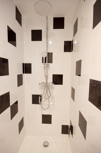 La salle de bains est pourvue d'une douche avec du carrelage noir et blanc. dans l'établissement L'Eco Studio - Vue Panoramique, à Angoulême