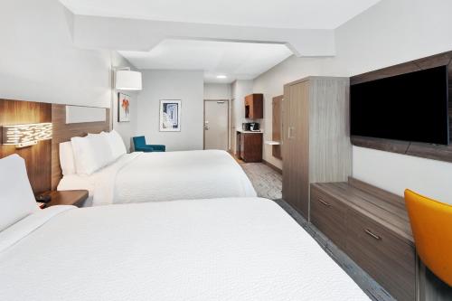 a hotel room with two beds and a flat screen tv at Holiday Inn Express & Suites Carmel North – Westfield by IHG in Carmel