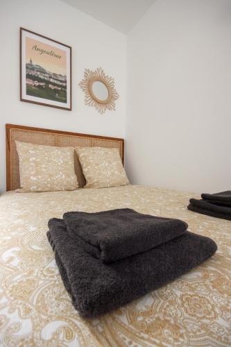- un lit avec une couverture noire dans l'établissement L'Eco Studio - Vue Panoramique, à Angoulême