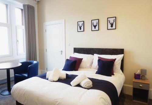 um quarto com uma cama grande e almofadas azuis e brancas em Jacobite house em Inverness