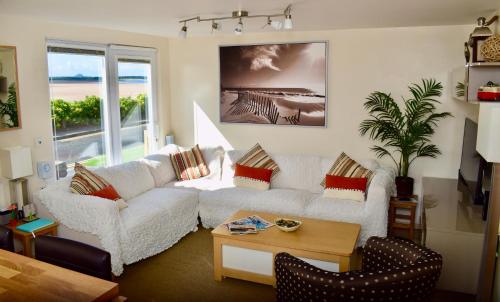 een woonkamer met een witte bank en een tafel bij Surfside Chalet in Dunbar
